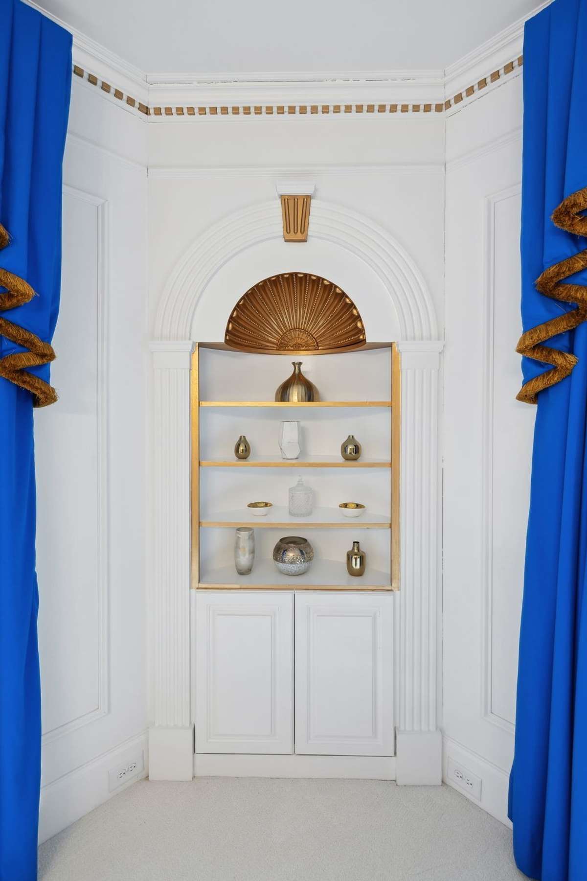 Custom corner shelving with gold shell trimwork