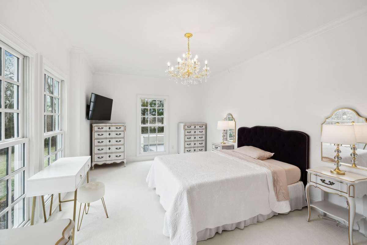 First floor bedroom with natural light, crystal chandelier, and ensuite.