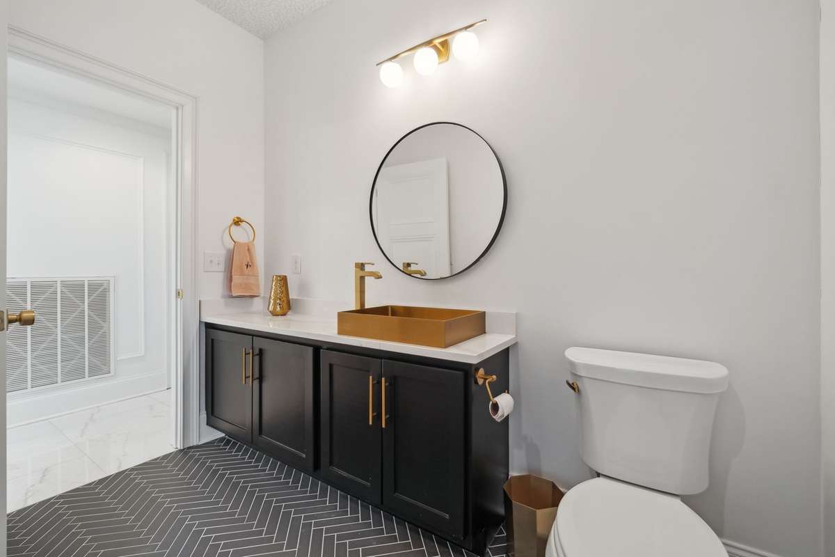 Half bathroom behind primary staircase with access to pool, full laundry, and refrigerator.
