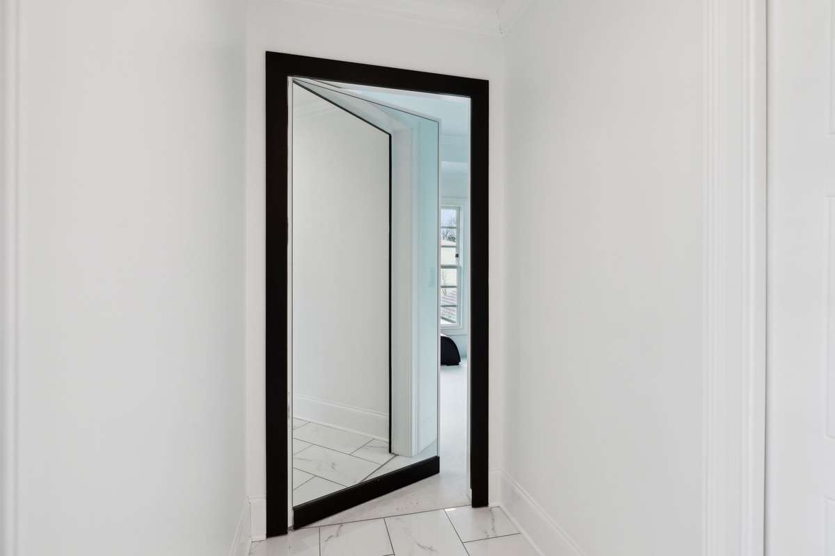 Hidden closet behind full length mirror in primary bathroom.