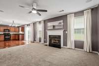 The great room, wired with a theater surround sound system including speakers and subwoofer, flows effortlessly into the open kitchen, making it ideal for both everyday living and entertaining.