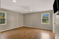 Primary bedroom also located upstairs with laminte flooring, a ceiling fan, and ample lighting. Located on the back of the home for the golf course view!