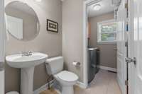 Main floor half bath with laundry and additional storage cabinets.