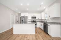 Kitchen with white shaker cabinets and island, granite countertops and stainless steel appliances