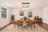 Spacious dining room offers an updated lighting fixture... the door on the right allows access to the basement.