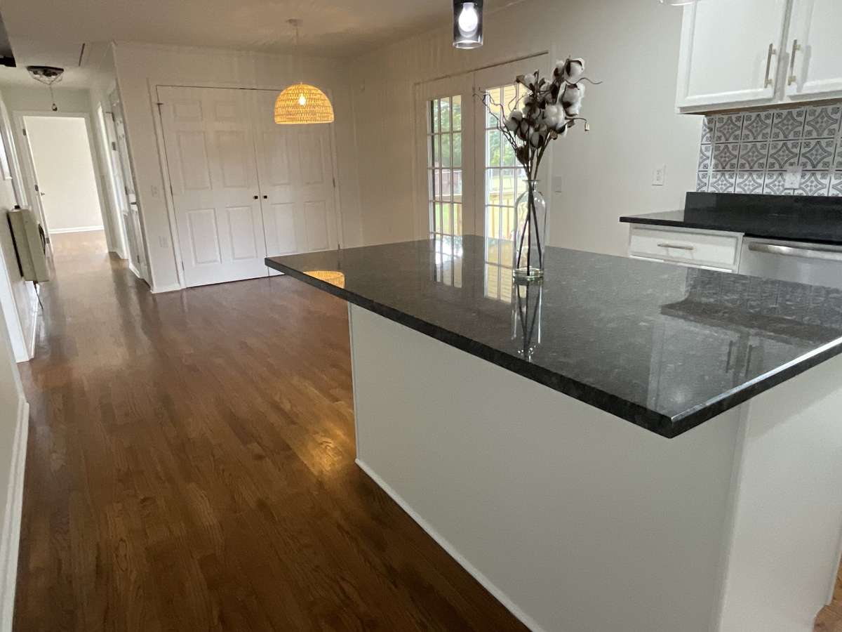 The dining area with the stylish rattan light with laundry behind the double doors