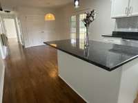 The dining area with the stylish rattan light with laundry behind the double doors