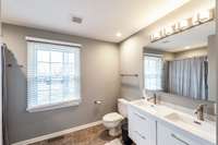 The primary ensuite bathroom features a double vanity and abundant storage.