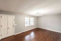 The formal living room is highlighted by stunning hardwood floors, creating an elegant and inviting atmosphere.