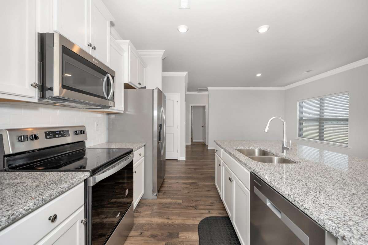 Kitchen- lvp flooring, open floorplan, granite countertops, kitchen island with bar seating, pantry, stainless steel appliances- refrigerator, microwave, oven. cooktop