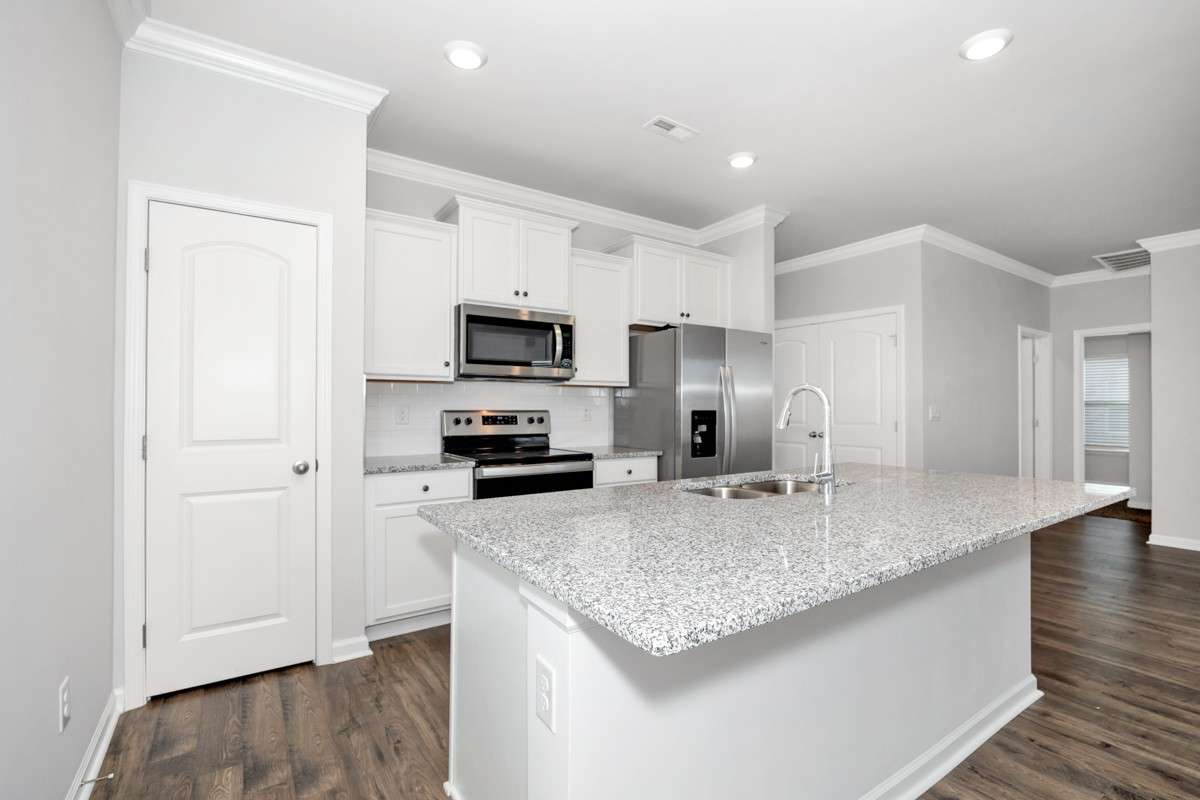 Kitchen- lvp flooring, open floorplan, granite countertops, kitchen island with bar seating, pantry, stainless steel appliances- refrigerator, microwave, oven. cooktop