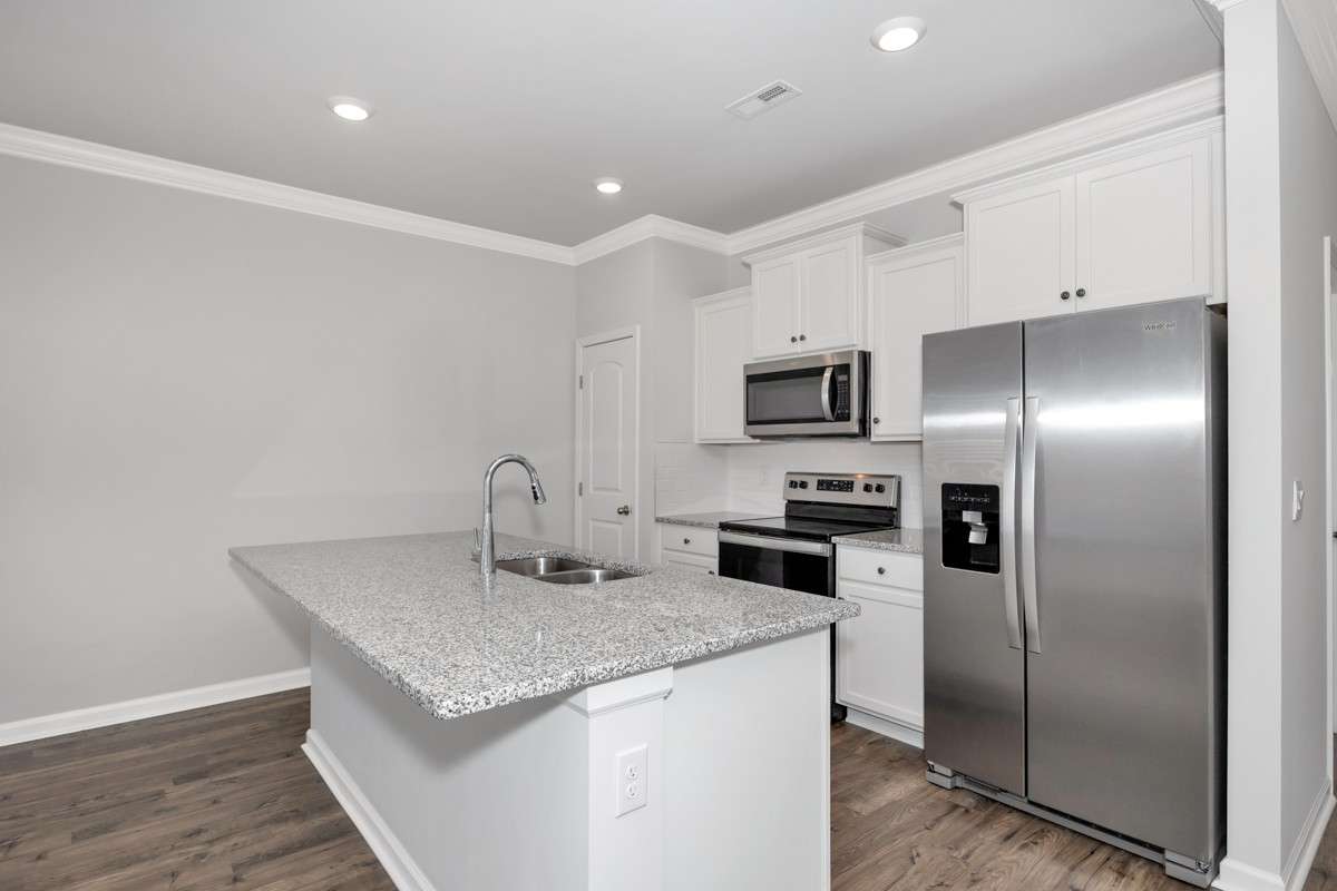 Kitchen- lvp flooring, open floorplan, granite countertops, kitchen island with bar seating, pantry, stainless steel appliances- refrigerator, microwave, oven. cooktop