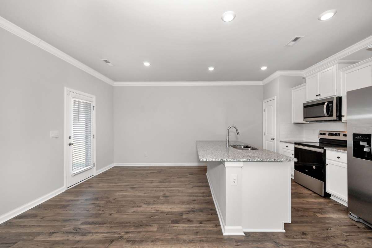 Kitchen- lvp flooring, open floorplan, granite countertops, kitchen island with bar seating, pantry, stainless steel appliances- refrigerator, microwave, oven. cooktop