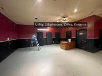 Utility closet with plumbing, 2 bathrooms, a closet and a large open event or retail space.