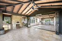 Custom one-touch glide accordion doors from Iron Lion make connection easy to the screened-in patio. You’ll enjoy a wood fired pizza oven, DCS gas grill and rotisserie, and drink drawers in your summer kitchen.