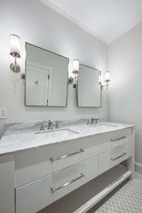 The accompanying bathroom features beautiful tile work and double vanities. This bathroom also features a shower/tub combination.