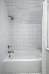 The accompanying bathroom features beautiful tile work and double vanities. This bathroom also features a shower/tub combination.