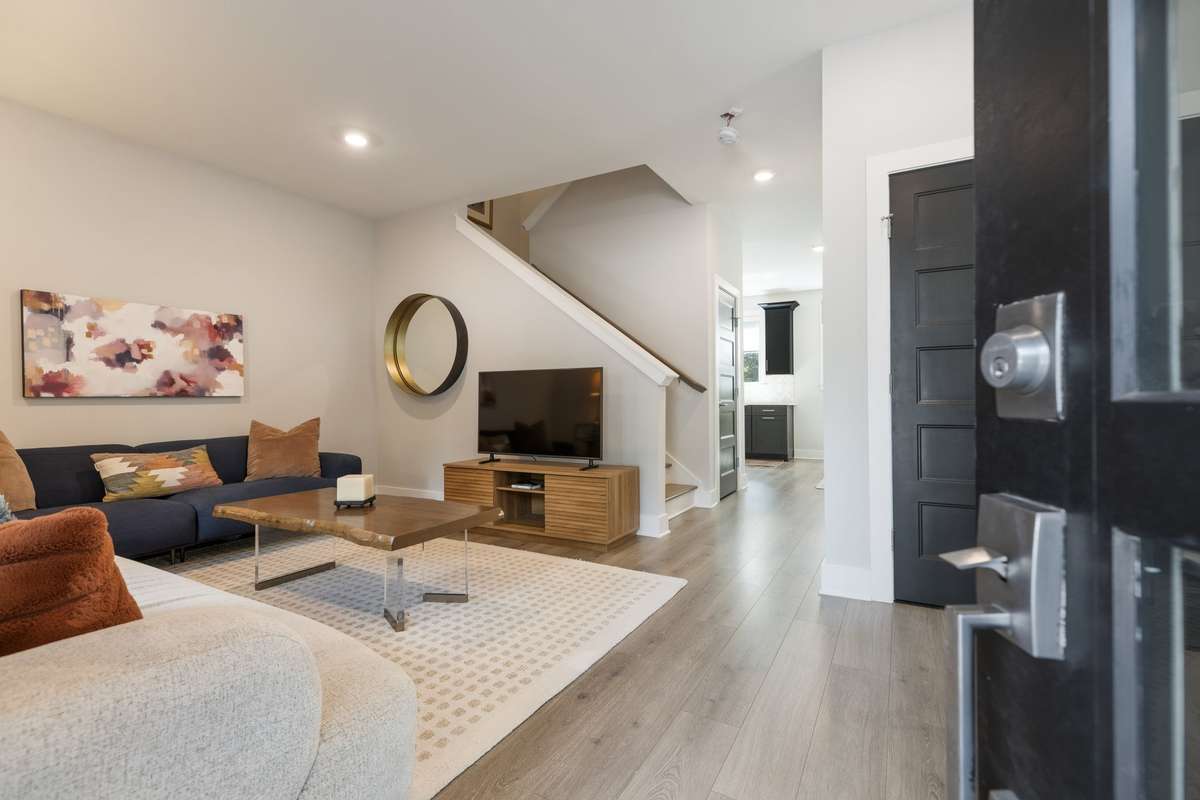 A large living room, easy to care for LVP flooring modern black and white finishes welcome you inside the home.