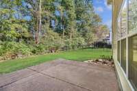Large outdoor aggregate patio overlooks mature trees . . .for wonderful privacy.  (Photo virtually brightened)