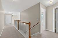 Upstairs hallway leads to open bonus room on one end and primary bedroom on the other end.  Smooth ceilings in entire home