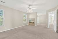 Primary suite view into its own private sitting room and double-sided fireplace with gas logs