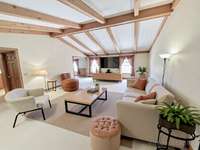 The great room impresses with a vaulted ceiling and gorgeous wood beams, providing the ideal gathering space for family and friends. Virtually staged photo for inspiration only and to showcase how space can be used and furnished.