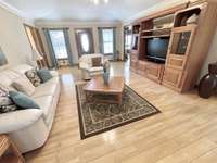 Enjoy a spacious living room with wide-plank hardwood floors, an elegant raised tray ceiling, and a fireplace that adds architectural appeal.