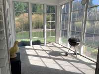 Sunroom with plastic windows and window screens.