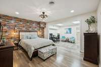 Primary bedroom includes a versatile sitting area—perfect for an office or reading nook and Peel-&-stick accent wallpaper on the bed wall. This space also features a private garage entrance and an adjoining bonus area currently used as a home gym.