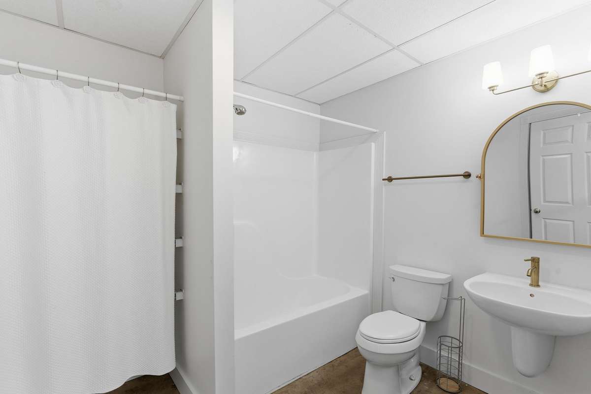 Lower level features a spacious blue primary bedroom with full bath and convenient kitchenette, ideal for an in-law suite, guests, or long-term stays, complete with its own private entrance.