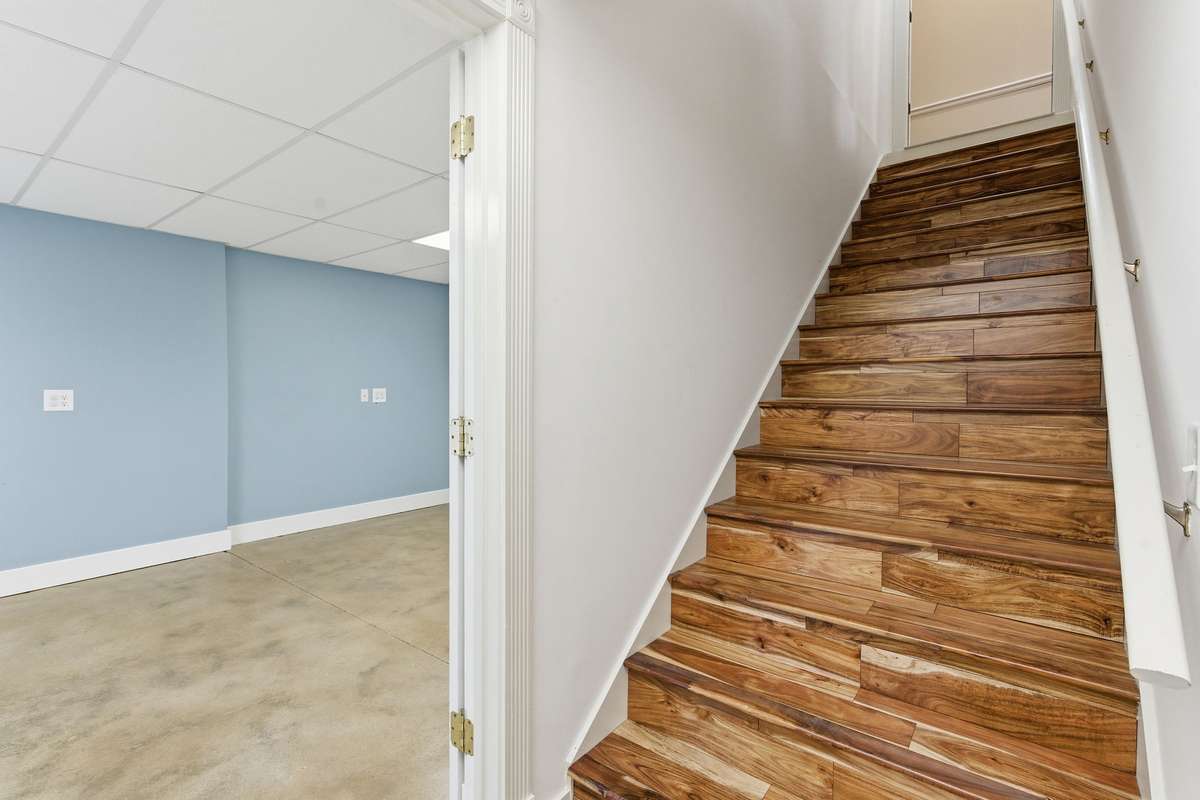 Wood treads lead down to the full finished basement, expanding the home’s living and entertaining space.