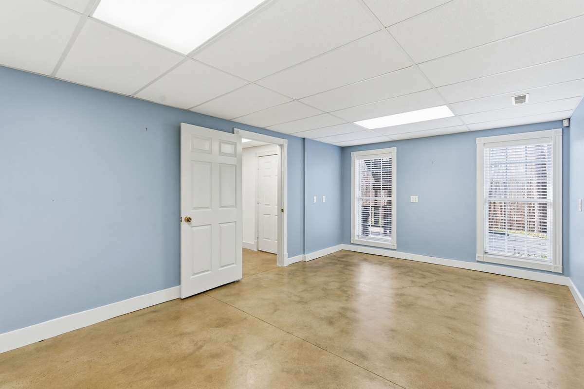 Lower level features a spacious blue primary bedroom with full bath and convenient kitchenette, ideal for an in-law suite, guests, or long-term stays, complete with its own private entrance.