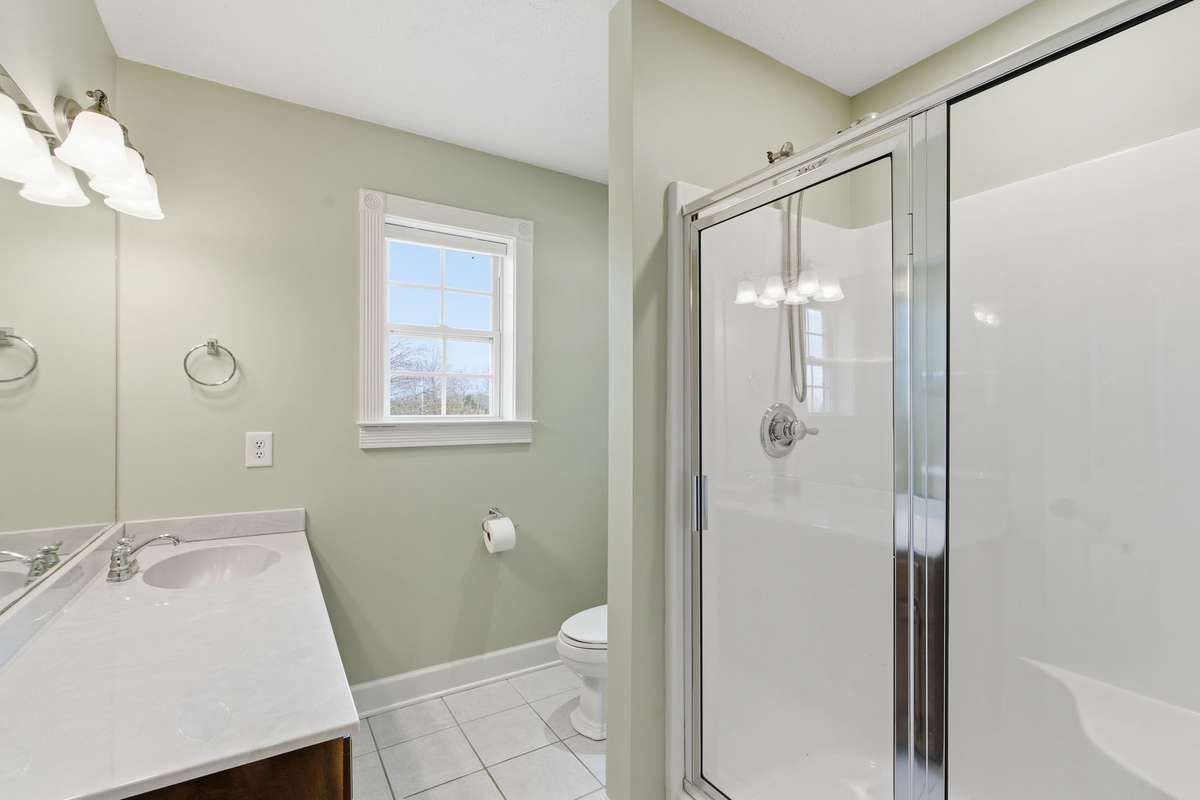 Bright upstairs hallway full bath with a large walk-in shower and extended vanity, ideal for two bedrooms to share or welcoming guests, with convenient access to the nearby bonus room.