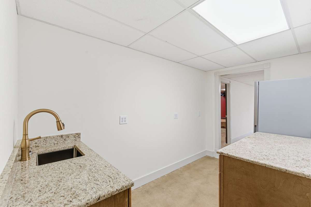 Lower level features a spacious blue primary bedroom with full bath and convenient kitchenette, ideal for an in-law suite, guests, or long-term stays, complete with its own private entrance.