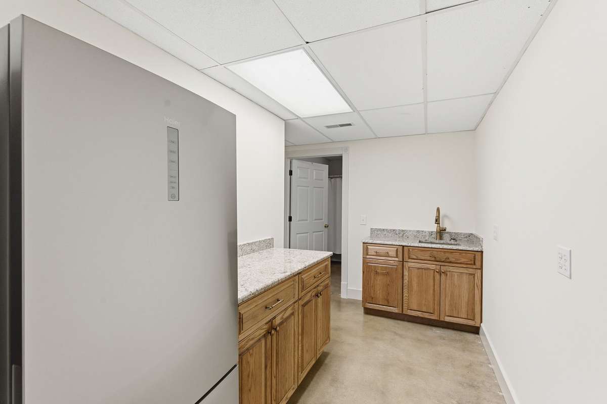 Lower level features a spacious blue primary bedroom with full bath and convenient kitchenette, ideal for an in-law suite, guests, or long-term stays, complete with its own private entrance.