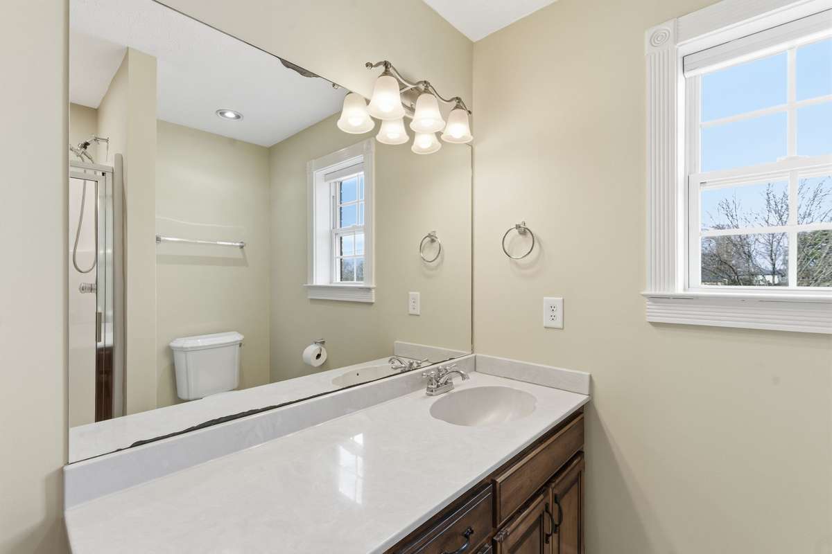 Bright upstairs hallway full bath with a large walk-in shower and extended vanity, ideal for two bedrooms to share or welcoming guests, with convenient access to the nearby bonus room.