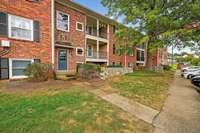 Classic red-brick exterior with charming colonial details and a covered balcony.