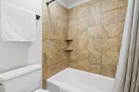 Tiled shower with a separate entry door for privacy.