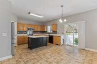View of the kitchen and eat in area. The sliding glass door leads to the fantastic covered patio area, pool, fire pit, and grassy area.