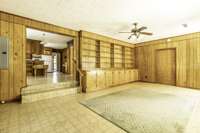 Den with steps to dining/kitchen area