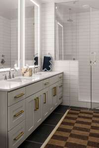 Back-lit bathroom mirrors and double vanities with rainfall shower.