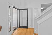 The front entry makes an elegant statement, featuring a striking new wood door with clear glass, paired with a storm door for added durability and seasonal comfort