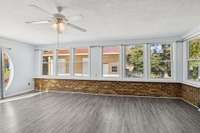 Owners enclosed carport to add sunroom.  Wall of windows feels like the outdoors are coming in. Sunny and cheery.  MNew mini-split HVAC, ceiing fan.