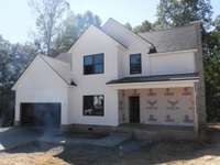 Here's your great looking white farmhouse with black trimmed windows. Lots of interior choices still to be made at the time of listing. NO HOA here.... Sitting on 2.3 acres of land that actually has trees in the front yard and back yard.
