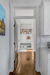 Beautifully captured doorway with restored door and transom leading to the guest room, full bath, mudroom, pantry, and office nook. The back door leading to the expansive back deck with full grilling setup and built in keg system.