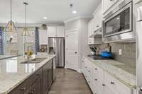 Granite! Stainless! Granite! Stainless appliances!  Pantry!!!Gas cooktop! Double Oven! Upper mounted Microwave! Undermount sink!  Chef's Kitchen.