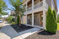 Exterior elevation shows a full length second story balcony which creates a prominent entrance, and shaded outdoor space on two levels.