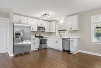 Kitchen features...white shaker style cabinets with soft close hinges, quartz countertops, stainless steel appliances, new lighting and those hardwoods!!!