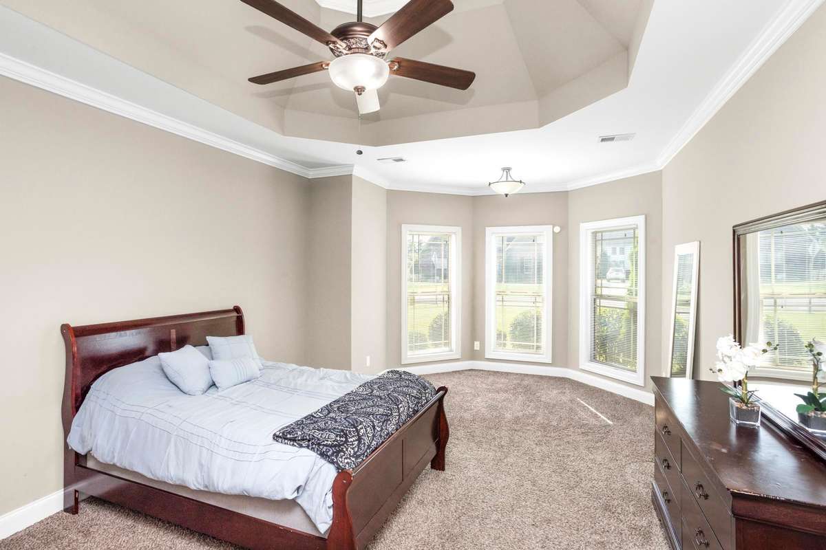 The primary bedroom is so welcoming and spacious! Bay windows let the light flow in!