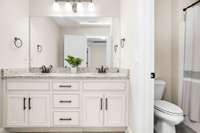 The large upstairs bath features double vanities and a tub/shower combo.